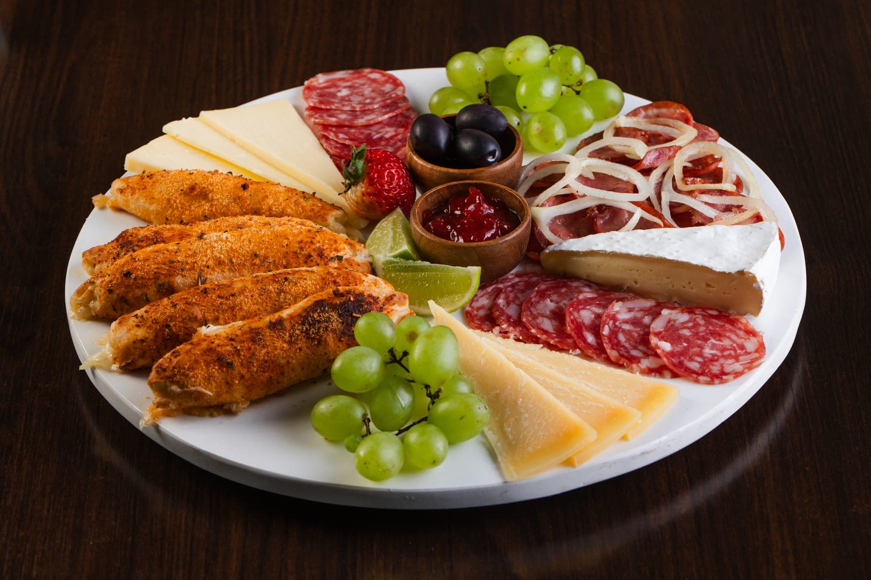 Tábua de petiscos com frios, queijos, uvas e frango empanado